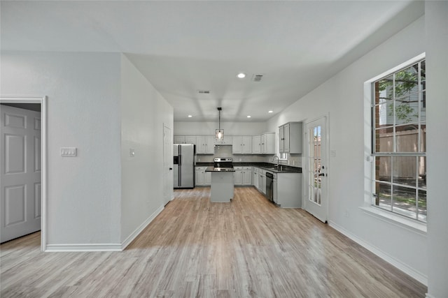 1100 Hyde Park Dr, Mckinney, TX 75069 - kitchen featuring appliances with stainless steel finishes, dark countertops, a sink, light wood-style flooring, and baseboards