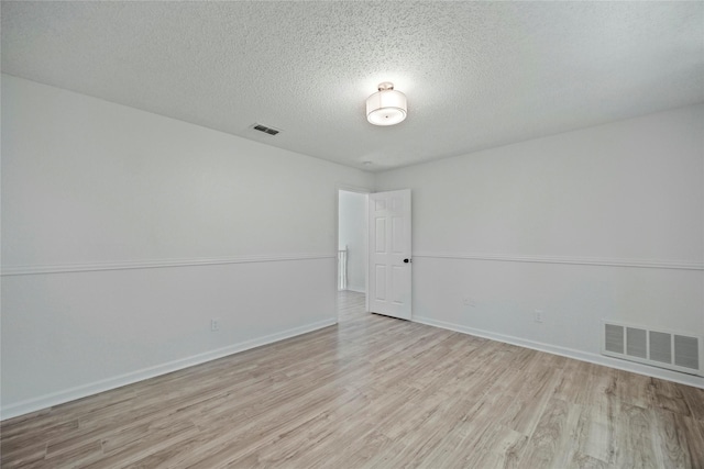 1100 Hyde Park Dr, Mckinney, TX 75069 - empty room with wood finished floors, a textured ceiling, and baseboards