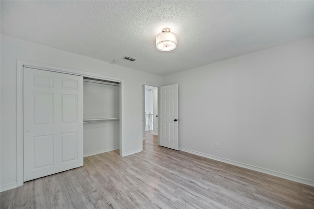 1100 Hyde Park Dr, Mckinney, TX 75069 - unfurnished bedroom with light wood-style flooring, a closet, a textured ceiling, and baseboards