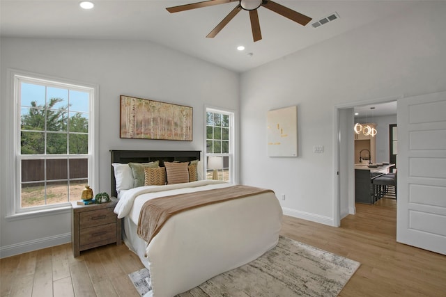 bedroom featuring baseboards, multiple windows, light wood-type flooring, vaulted ceiling, and recessed lighting
