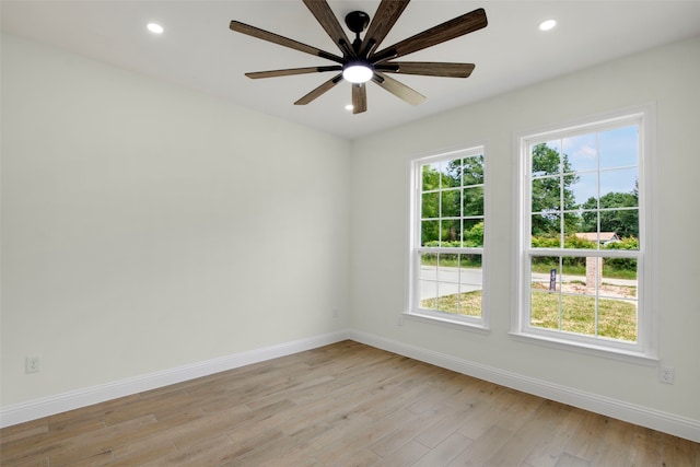spare room featuring baseboards, plenty of natural light, light wood-type flooring, recessed lighting, and ceiling fan