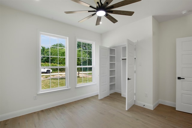 unfurnished bedroom featuring baseboards, light wood-style flooring, and a ceiling fan