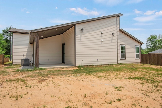 rear view of property featuring fence, a patio area, and cooling unit
