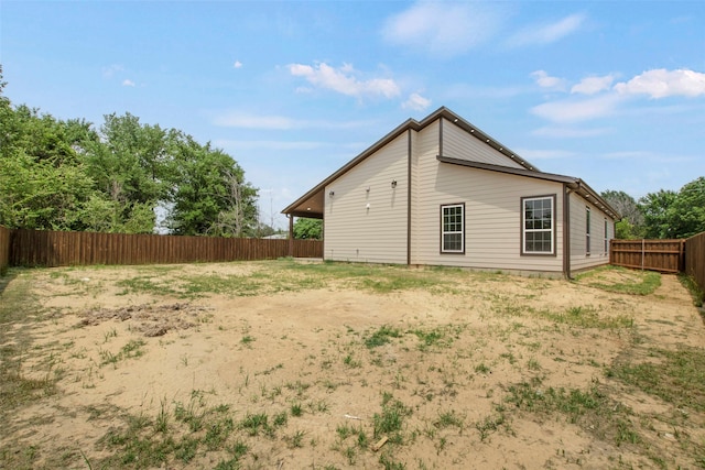 rear view of house with a fenced backyard