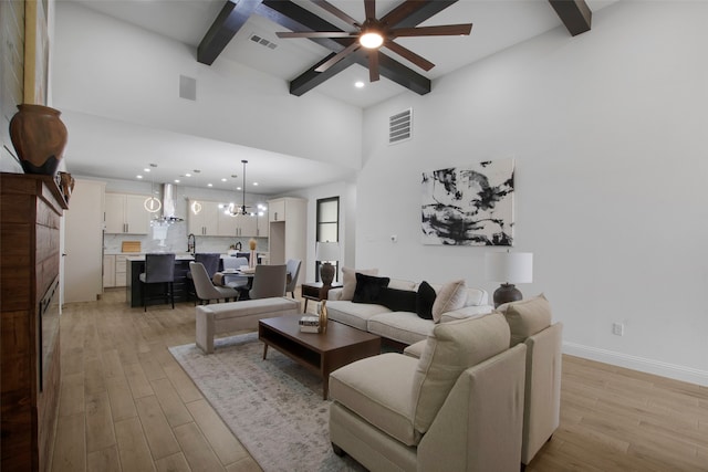 living room with beam ceiling, a ceiling fan, light wood-style flooring, recessed lighting, and a chandelier