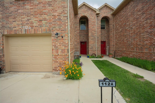 112 Wood St Unit A, Princeton, TX 75407 - view of front of house with a garage, concrete driveway, and brick siding