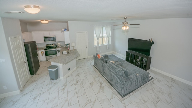 112 Wood St Unit A, Princeton, TX 75407 - living area with light marble finish floors, a ceiling fan, and baseboards