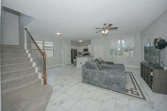 112 Wood St Unit A, Princeton, TX 75407 - living area featuring light marble finish flooring, a ceiling fan, stairs, and baseboards