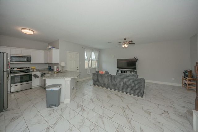 112 Wood St Unit A, Princeton, TX 75407 - kitchen with stainless steel appliances, open floor plan, light marble finish floors, a peninsula, and a ceiling fan