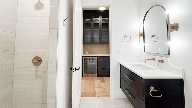 1596 Maple, Tyler, TX 75703 - bathroom featuring wine cooler, vanity, a tile shower, and tile patterned floors