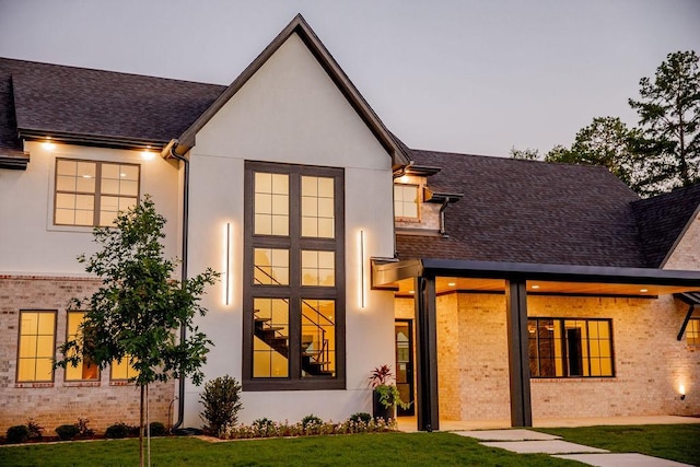 1596 Maple, Tyler, TX 75703 - rear view of house featuring stucco siding, a yard, and brick siding