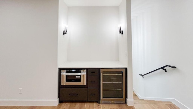 1596 Maple, Tyler, TX 75703 - bar area featuring beverage cooler, light wood-style floors, baseboards, and stainless steel oven