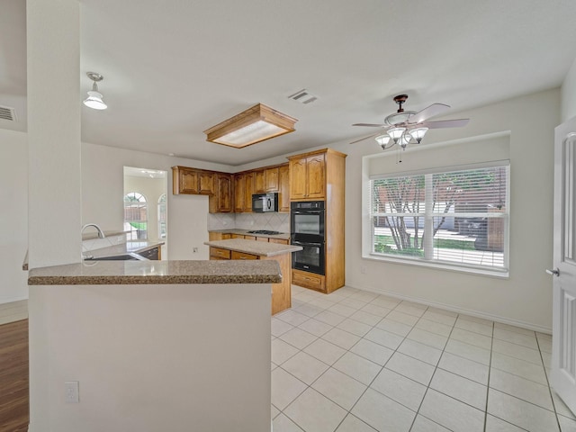 348 Kansas Trl, Murphy, TX 75094 - kitchen featuring black appliances, a sink, decorative backsplash, a peninsula, and brown cabinetry