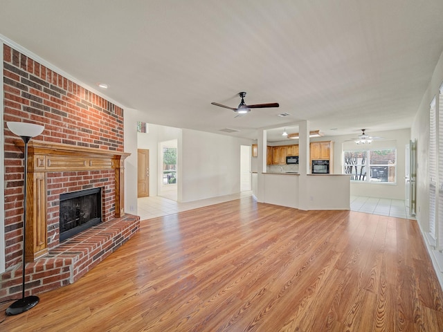 348 Kansas Trl, Murphy, TX 75094 - unfurnished living room with a ceiling fan, light wood finished floors, and a fireplace