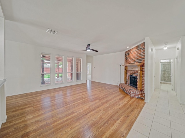 348 Kansas Trl, Murphy, TX 75094 - unfurnished living room with light wood-type flooring, a brick fireplace, ceiling fan, and baseboards