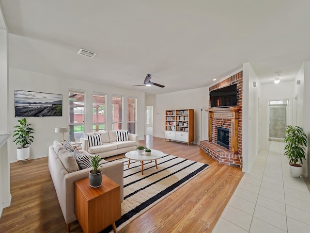 348 Kansas Trl, Murphy, TX 75094 - living room with a fireplace, light wood-style flooring, and ceiling fan