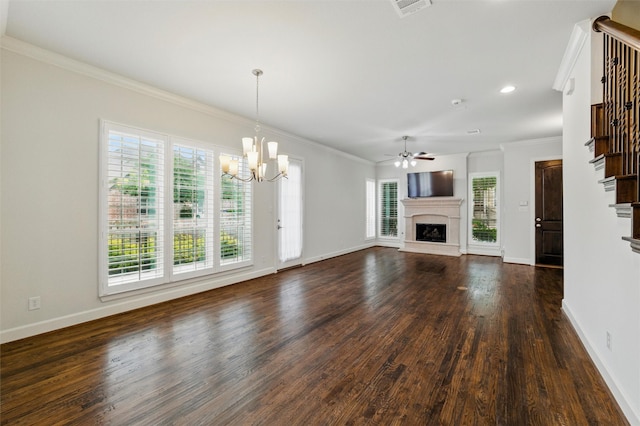 unfurnished living room featuring a fireplace with raised hearth, crown molding, dark wood-style flooring, a ceiling fan, and a chandelier