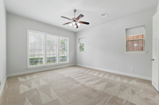 spare room featuring a ceiling fan, carpet floors, and baseboards