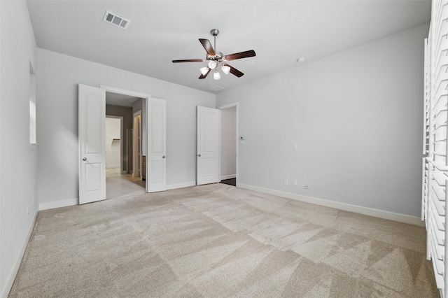 unfurnished bedroom featuring light carpet, baseboards, and a ceiling fan