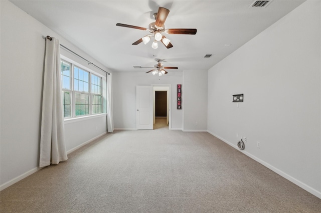 spare room featuring light carpet and baseboards