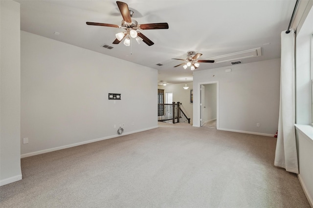 unfurnished room with attic access, ceiling fan, light colored carpet, and baseboards