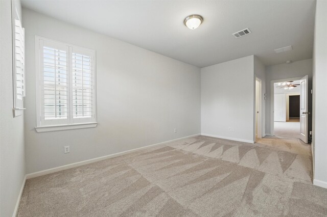carpeted empty room with baseboards and a ceiling fan