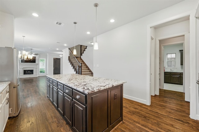 kitchen with freestanding refrigerator, dark wood-type flooring, open floor plan, a chandelier, and baseboards