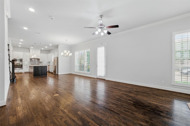 unfurnished living room featuring a chandelier, plenty of natural light, baseboards, crown molding, and recessed lighting