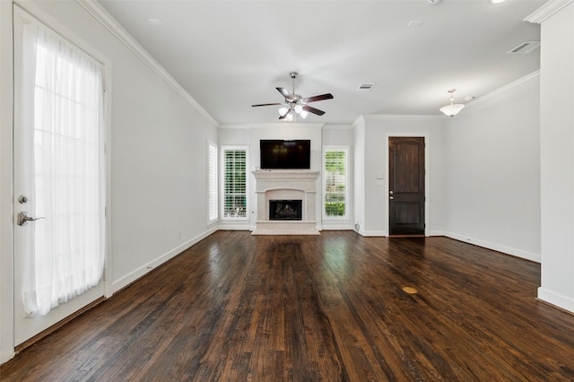 unfurnished living room featuring a fireplace with raised hearth, dark wood finished floors, ceiling fan, ornamental molding, and baseboards