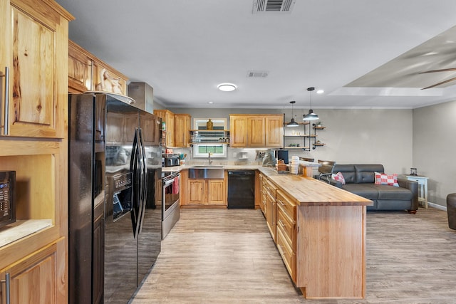 3266 Farm Rd Unit 1159, Clarksville, TX 75426 - kitchen featuring black appliances, a peninsula, a sink, open floor plan, and light wood-style flooring