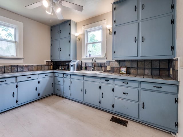 320 S Ward St, Italy, TX 76651 - kitchen with a sink, ceiling fan, tasteful backsplash, tile countertops, and blue cabinets