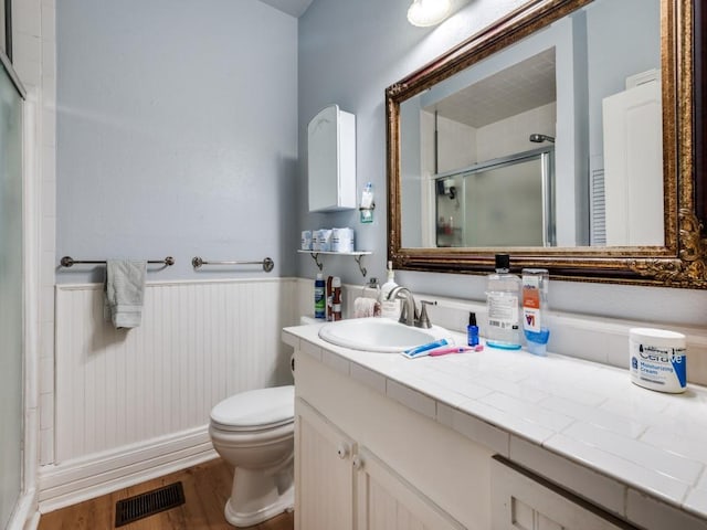 320 S Ward St, Italy, TX 76651 - bathroom featuring a shower stall, wainscoting, wood finished floors, toilet, and vanity