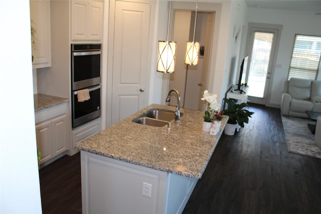 4804 Garner Dr, Carrollton, TX 75010 - kitchen with a sink, stainless steel double oven, dark wood-style flooring, and white cabinets