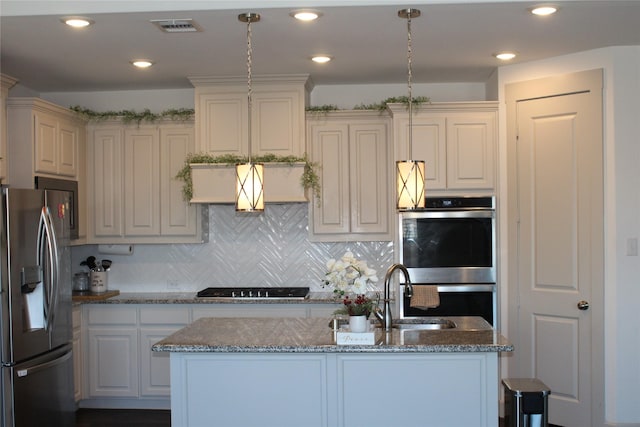4804 Garner Dr, Carrollton, TX 75010 - kitchen featuring appliances with stainless steel finishes, stone counters, a sink, a center island with sink, and decorative backsplash
