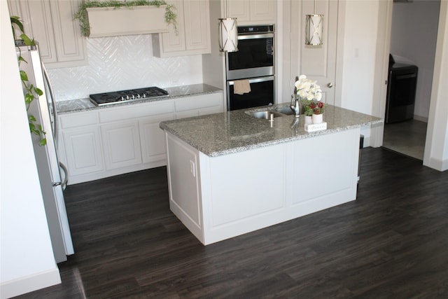 4804 Garner Dr, Carrollton, TX 75010 - kitchen featuring double oven, washer / clothes dryer, dark wood-style flooring, freestanding refrigerator, and gas cooktop