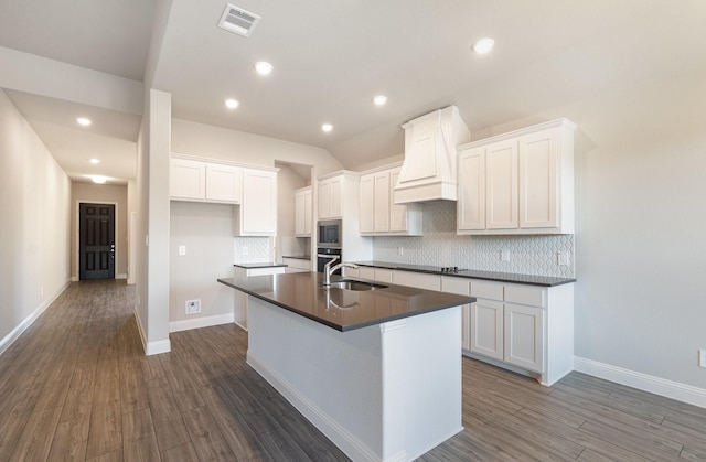 620 Alaina Dr, Desoto, TX 75115 - kitchen featuring custom range hood, dark countertops, a sink, appliances with stainless steel finishes, and a kitchen island with sink