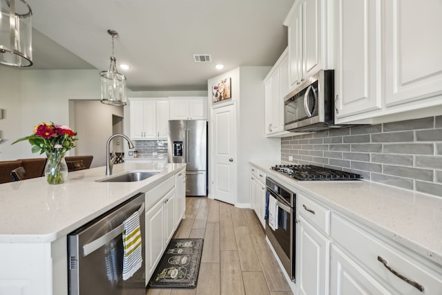 3120 Pioneer Path, Little Elm, TX 75068 - kitchen featuring a sink, stainless steel appliances, white cabinets, an island with sink, and light wood finished floors