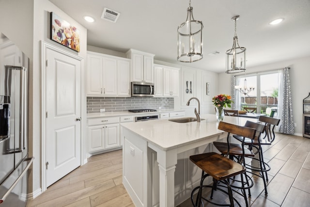 3120 Pioneer Path, Little Elm, TX 75068 - kitchen with appliances with stainless steel finishes, a sink, tasteful backsplash, an island with sink, and a breakfast bar