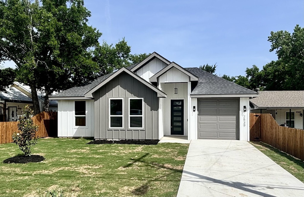 2539 Randolph St, Dallas, TX 75241 - view of front facade with board and batten siding, an attached garage, and a shingled roof