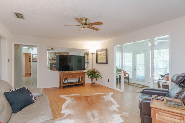 226 Highland Dr, Decatur, TX 76234 - living room featuring a ceiling fan, a textured ceiling, light wood-type flooring, and crown molding