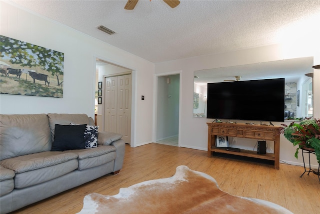226 Highland Dr, Decatur, TX 76234 - living room featuring wood finished floors, a ceiling fan, and a textured ceiling