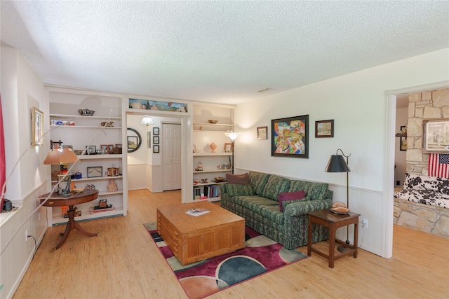 226 Highland Dr, Decatur, TX 76234 - living room with a textured ceiling, wood finished floors, wainscoting, and built in features
