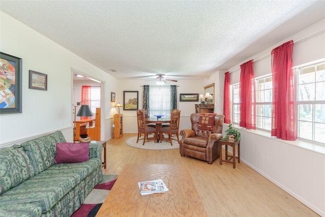226 Highland Dr, Decatur, TX 76234 - living room featuring light wood finished floors, a textured ceiling, healthy amount of natural light, and ceiling fan