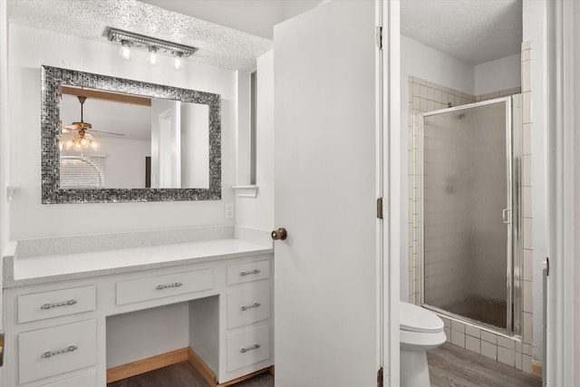 2000 Stacey Ct, Arlington, TX 76013 - bathroom with a textured ceiling, toilet, a stall shower, wood finished floors, and vanity