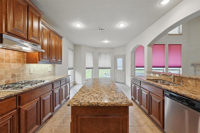6824 San Fernando Dr, Fort Worth, TX 76131 - kitchen featuring stainless steel appliances, under cabinet range hood, a sink, light stone countertops, and arched walkways