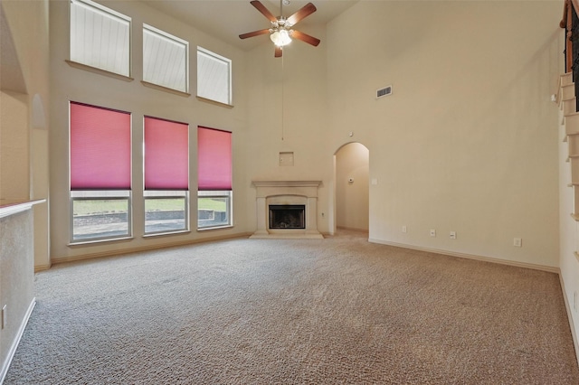 6824 San Fernando Dr, Fort Worth, TX 76131 - unfurnished living room with a ceiling fan, carpet, a towering ceiling, a high end fireplace, and arched walkways