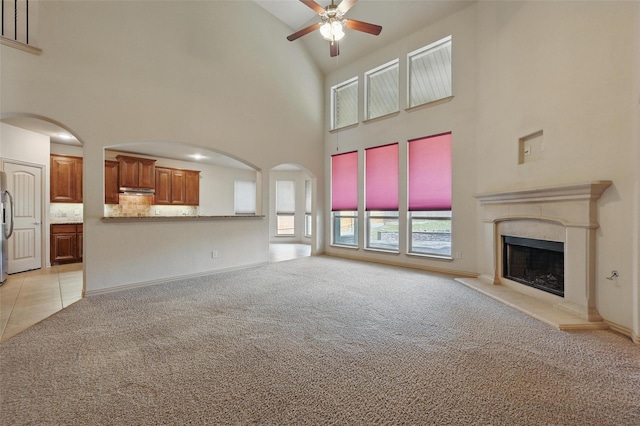 6824 San Fernando Dr, Fort Worth, TX 76131 - unfurnished living room featuring a ceiling fan, light colored carpet, high vaulted ceiling, a fireplace, and arched walkways
