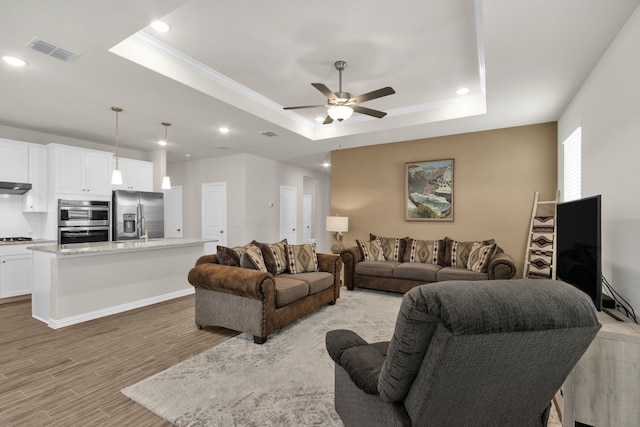 2420 Rooster Ln, Northlake, TX 76247 - living area with a tray ceiling, a ceiling fan, light wood-style flooring, recessed lighting, and ornamental molding