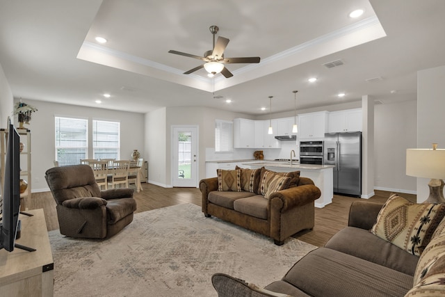 2420 Rooster Ln, Northlake, TX 76247 - living room featuring a tray ceiling, wood finished floors, ornamental molding, a ceiling fan, and recessed lighting