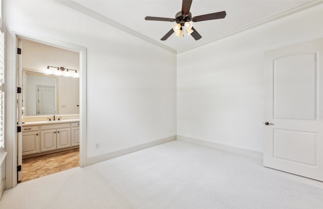 unfurnished bedroom with a sink, light carpet, crown molding, connected bathroom, and ceiling fan